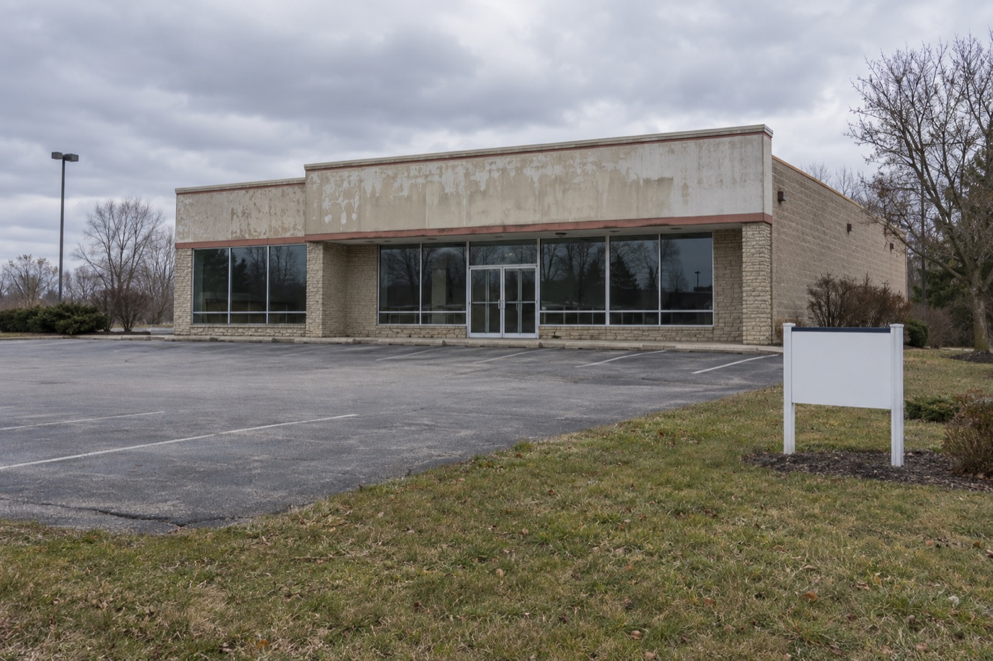 Vacant commercial building with an empty lot, the kind of property often sold at auction